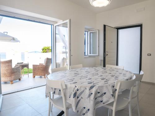 a white dining room with a table and chairs at Villa Marisa - Villa di Lusso Fronte Spiaggia in Cittadella del Capo