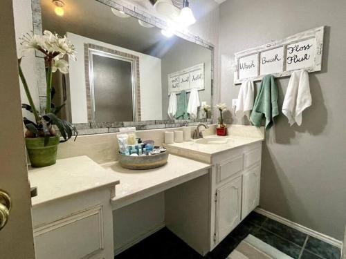 a white bathroom with a sink and a mirror at Rest, Relax & enjoy the entire cozy vacational home! in Mission