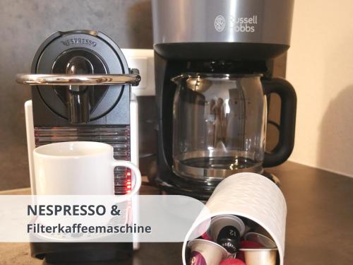 a coffee maker and a coffee mug on a counter at FeWo schwarzwaldschick Feldberg I wandern & biken ab Haustür I Whirlpool & Wlan & Balkon & Tiefgarage in Feldberg