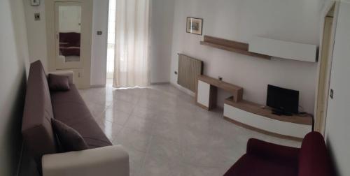 een woonkamer met een bank en een televisie bij Casa Rosina in Castrignano del Capo