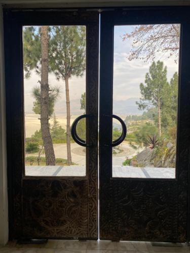 an open door with a view of a tree at Rock City Resort in Mingora