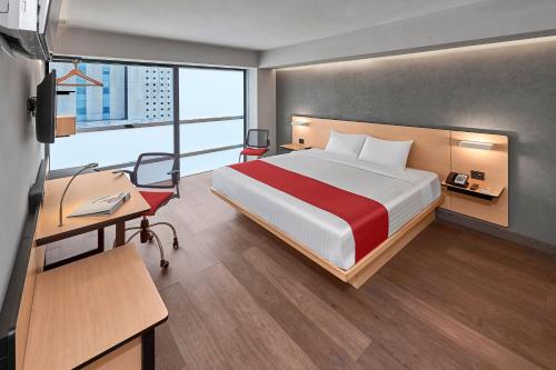a hotel room with a bed and a desk and a desk at City Express by Marriott EBC Reforma in Mexico City