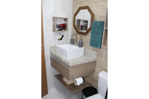 a bathroom with a sink and a mirror at Makambira Residence no Centro de Porto de GalinhaS in Porto De Galinhas