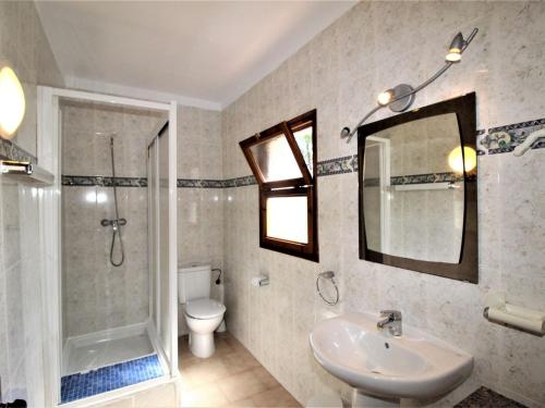 y baño con lavabo, ducha y aseo. en Apartments La Pineda, Playa de Pals, en Begur