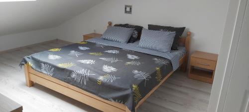 sypialnia z łóżkiem z czarno-żółtą kołdrą w obiekcie Tina apartman w mieście Prnjavor