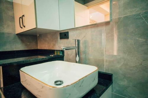 La salle de bains est pourvue d'un lavabo blanc et d'un miroir. dans l'établissement Villa Karam, à Kocaeli