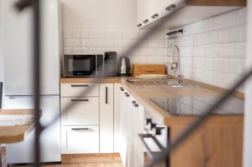 a kitchen with white cabinets and a microwave at Kuća za odmor Trota in Otočac
