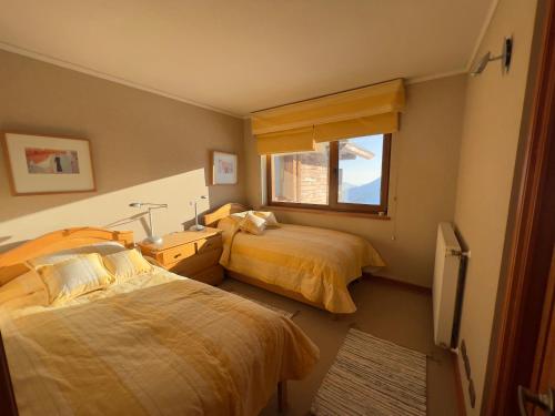 a bedroom with two beds and a window at Ski-in/out. Amplio y cómodo Departamento in Lo Barnechea