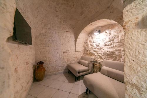 阿爾貝羅貝洛的住宿－Trullo Arboris，客厅配有两把椅子和电视
