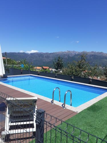 a large swimming pool with a fence around it at Casa dos Mirandas in Vieira do Minho