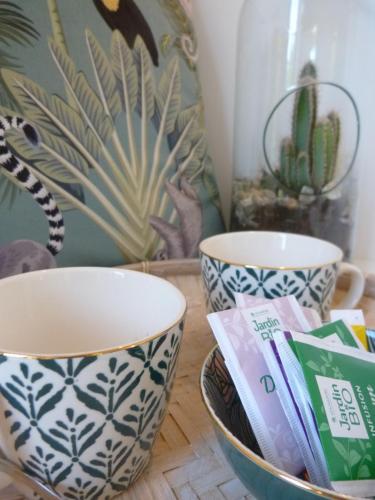 two cups and a bowl on a wooden table at La Désirade in Salles-la-Source