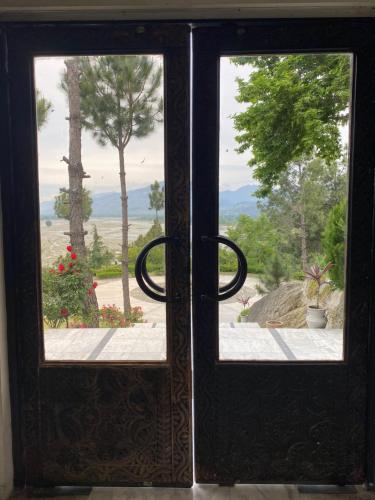 an open door with a view of a garden at Rock City Resort in Mingora