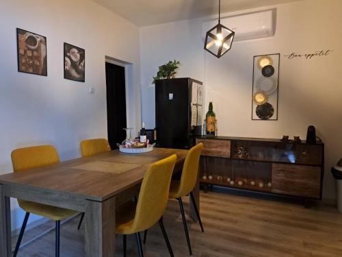 comedor con mesa de madera y sillas amarillas en Kuća za odmor Alea Rustica Daruvar en Daruvar