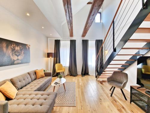 a living room with a couch and a staircase at Altstadt-Ferienwohnungen Braunschweig in Braunschweig