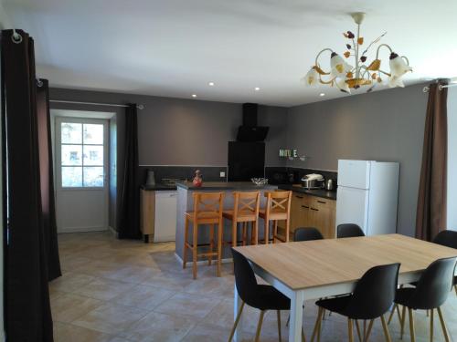 une cuisine avec une table, des chaises et un réfrigérateur dans l'établissement Domaine de Minodier - Gite 6 pers. (Chez Maryline), à Ardoix