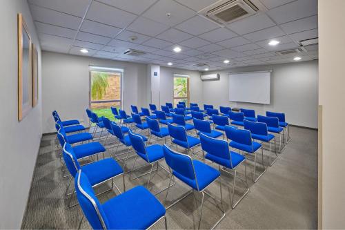 a conference room with blue chairs and a whiteboard at City Express by Marriott Minatitlán in Minatitlán