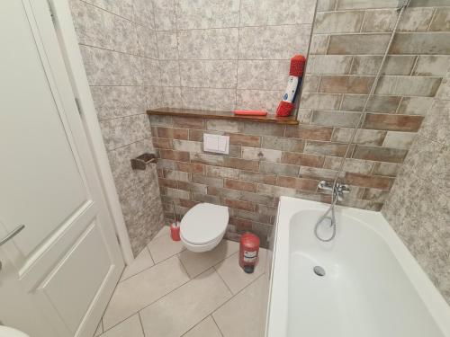 a bathroom with a toilet and a sink and a tub at Luxury Central Apartment One in Bacău