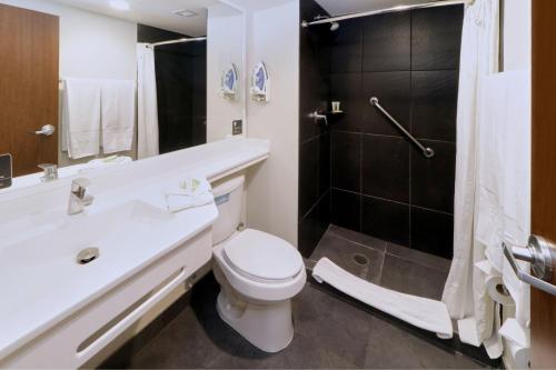 y baño con aseo, lavabo y ducha. en City Express Plus by Marriott Monterrey Nuevo Sur en Monterrey