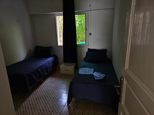 a small room with two beds and a window at Lagon appartement in Moulay Bousselham