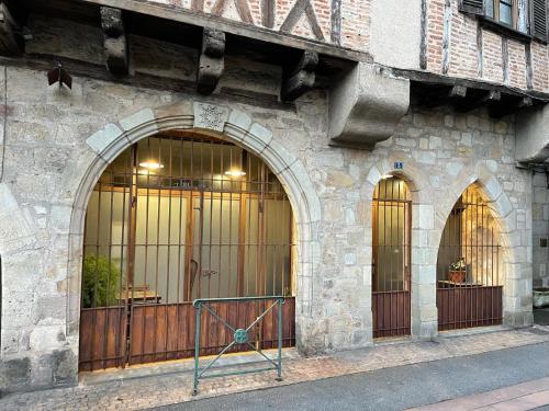 un edificio de piedra con dos entradas a un edificio en POPPY appartement de charme à 2 min centre-ville, en Figeac
