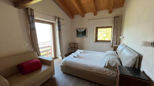 a bedroom with a bed and a couch and a window at Les Flocons Pila in Pila
