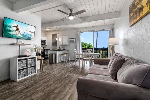 a living room with a couch and a dinning room at Kona Mansions#105 in Kailua-Kona