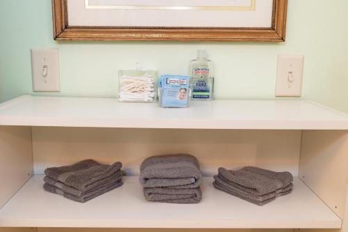 a shelf with towels and a mirror in a bathroom at Home STEPS from Oberlin in Oberlin