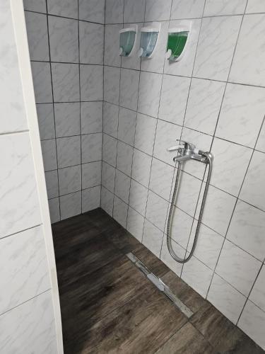 a shower with a hose on a tiled wall at 7DAB 0-9 contactless self check-in in Budapest