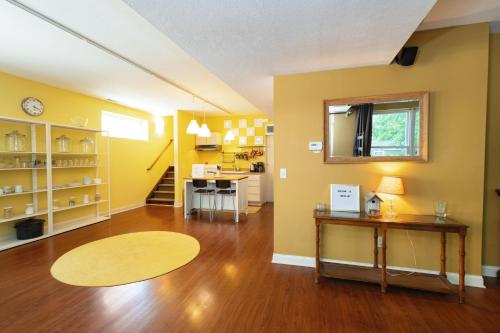 a living room with yellow walls and a wooden floor at Home STEPS from Oberlin in Oberlin