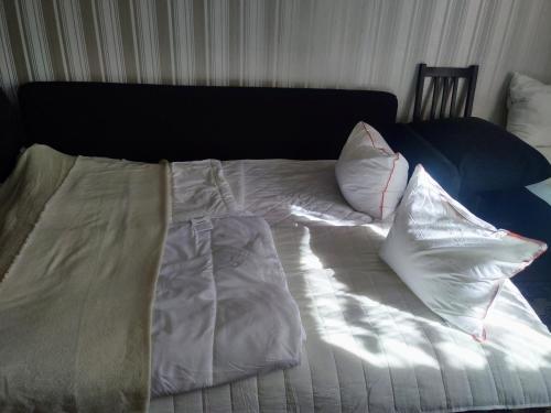 - un lit avec des draps et des oreillers blancs dans l'établissement Hus Näckrosen, à Ruda
