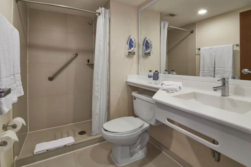 een badkamer met een toilet, een wastafel en een douche bij City Express by Marriott Puebla Angelopolis in Puebla