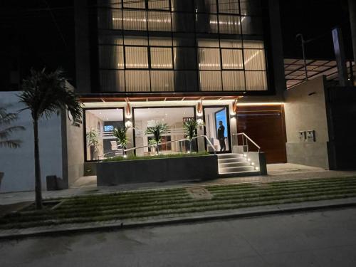 a person standing outside of a building at night at Grau Business Hotel in Piura