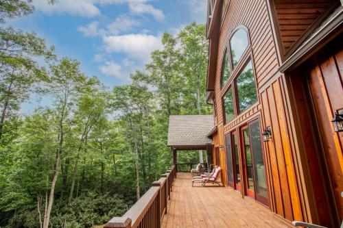 a deck on the side of a house with trees at Find The Joy in Blowing Rock