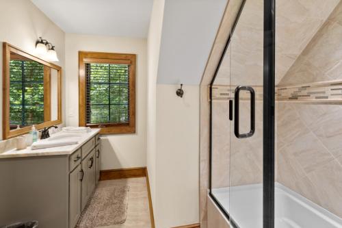 a bathroom with a shower and a sink and a tub at Find The Joy in Blowing Rock