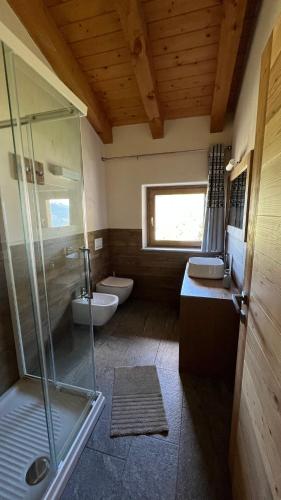 a bathroom with two toilets and a glass shower at Les Flocons Pila in Pila
