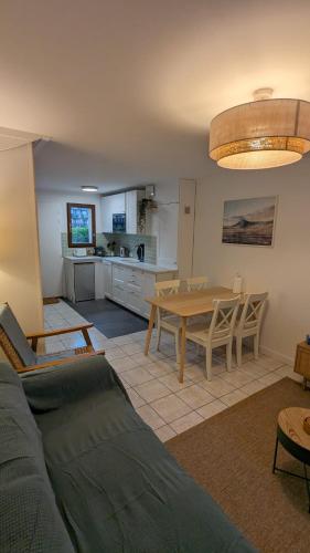 un salon avec une table et une cuisine dans l'établissement Cottage Cabourg plage avec jardin et vélos, à Cabourg