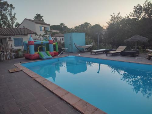 a swimming pool with a playground and a water slide at Mobilhomes vintage dans ecolieux en cours camping a la ferme in Ponteilla
