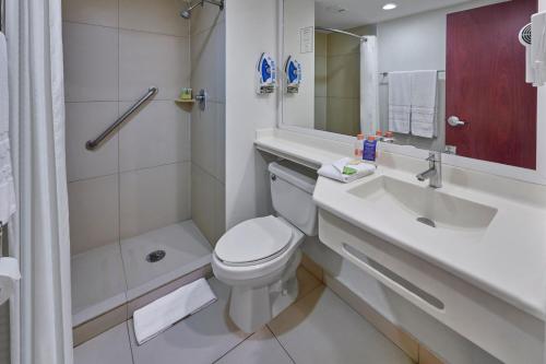 a bathroom with a toilet and a sink and a shower at City Express by Marriott Lazaro Cardenas in Lázaro Cárdenas