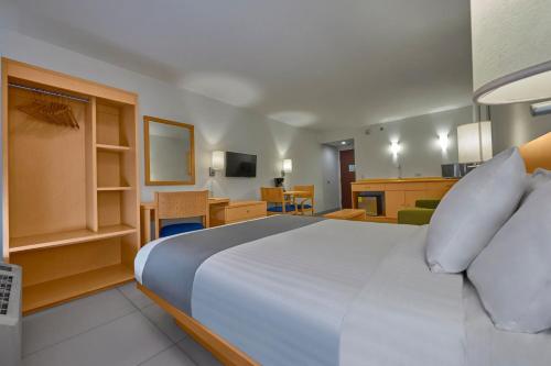 - une chambre avec un lit et un salon dans l'établissement City Express by Marriott Lazaro Cardenas, à Lázaro Cárdenas