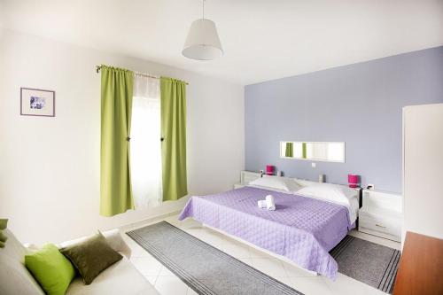 Schlafzimmer mit einem lila Bett und grünen Vorhängen in der Unterkunft House Stjepan in Krušvar