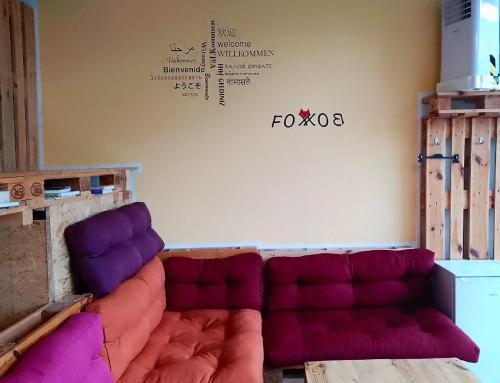 ein Wohnzimmer mit einem Sofa mit lila Kissen in der Unterkunft FOX BOX I Capsule Apt in Dresden