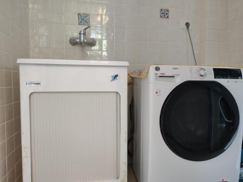 a washing machine in a bathroom with a sink at Endless Summer in Fontane Bianche