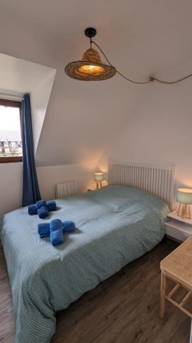 une chambre avec un lit avec deux serviettes bleues dessus dans l'établissement Cottage Cabourg plage avec jardin et vélos, à Cabourg