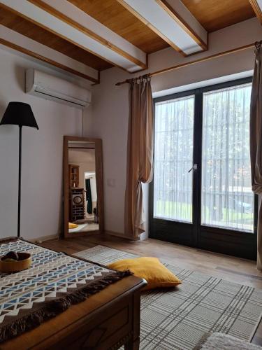 a bedroom with a bed and a large window at Bajka in Valjevo