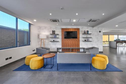 a living room with a couch and chairs and a tv at City Express by Marriott Monterrey Lindavista in Monterrey
