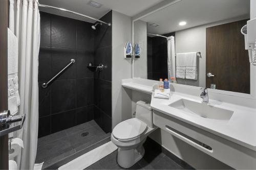 La salle de bains est pourvue de toilettes, d'un lavabo et d'une douche. dans l'établissement City Express by Marriott Monterrey Lindavista, à Monterrey