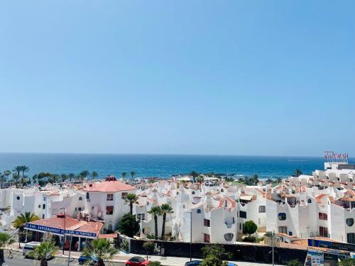 eine Stadt mit weißen Gebäuden und dem Meer in der Unterkunft Wonderful Sea view Yomeli in Playa de las Americas