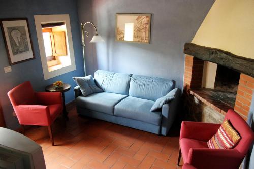 a living room with a blue couch and two chairs at Tuscany Villa Chianti Hills - Villa Oliveta in Loro Ciuffenna