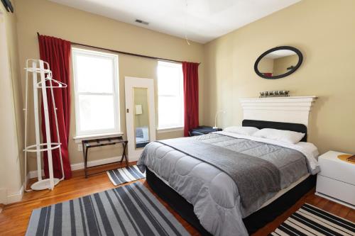 1 dormitorio con 1 cama grande y espejo en Small Suite STEPS from Oberlin, en Oberlin