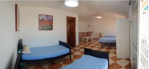 a room with two beds and a hallway with two beds at Casita Beach Front in Torrox Costa